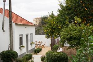 un albero di arancio di fronte a una casa bianca di Casa do Avô Serra a Leiria