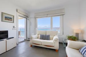 a living room with a white chair and a television at Apartament Platja Palangrers in Roses