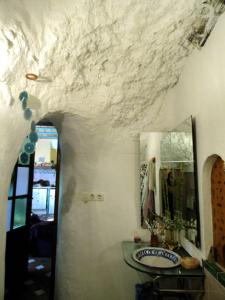 y baño con lavabo y espejo. en La Constanza Casa Cueva en Granada