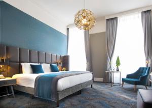 a bedroom with a large bed and a blue wall at Iveagh Garden Hotel in Dublin