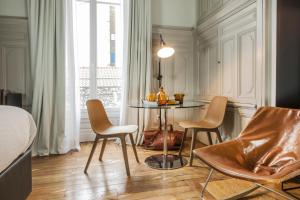 a room with a table and chairs and a bed at MiHotel Gailleton in Lyon