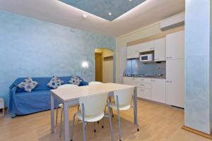 a kitchen with a table, chairs and a refrigerator at Residence Dei Due Porti in Sanremo