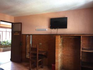 a room with a fireplace with a television on the wall at Hotel San Agustin in Puebla