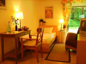 a bedroom with a bed and a desk and a chair at Seminarhotel Jakobsberg in Grünberg