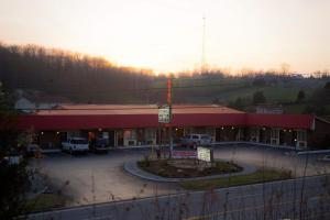 a building with a red roof and a parking lot at Tazewell Motor Lodge in Tazewell