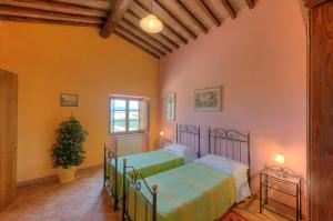 2 letti in una camera con pareti arancioni di Agriturismo Villa Felice a Volterra
