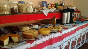 a table topped with different types of bread and pastries at Pousada Recanto São Benedito in Campos do Jordão