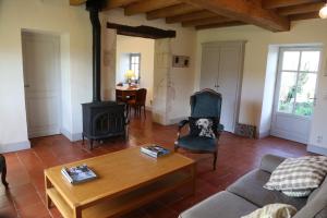 a living room with a couch and a wood stove at Chemin de Gargamelle Gite 'Mirabelle' in Ligueux