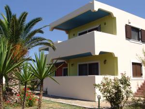 a white house with a blue roof at Terpsichore Apartments in Kyparissia