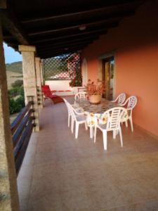 a patio with a table and chairs on a porch at Country House Vignola Mare in Aglientu