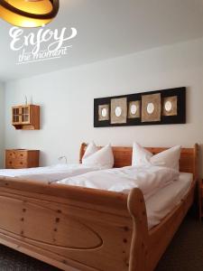 a bedroom with a wooden bed with white sheets at Gästehaus Stadtschaenke in Liebstadt