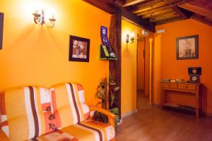 a yellow room with a couch and a table at Pensión la Campanilla in La Penilla