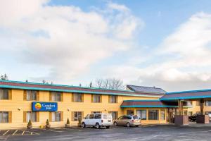 een gebouw met twee auto's geparkeerd op een parkeerplaats bij Quality Inn Kodiak in Kodiak