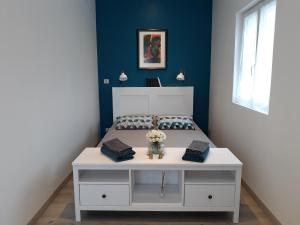 トゥールにある"Ô Tour's Angels" FEBVOTTEの白いテーブル付きのベッドが備わる客室です。
