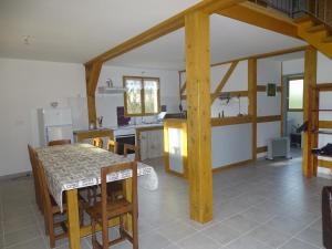 uma cozinha e sala de jantar com mesa e cadeiras em Gite de l'étang em Belval-en-Argonne