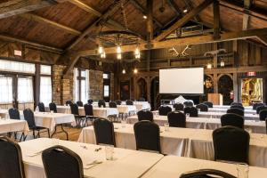 uma sala de conferências com mesas e cadeiras e um ecrã de projecção em Abe Martin Lodge & Cabins em Nashville