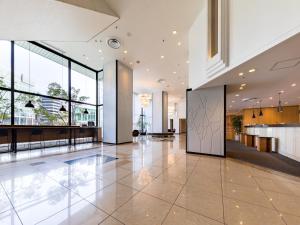 a lobby of a building with large windows at Nishitetsu Inn Fukuoka in Fukuoka