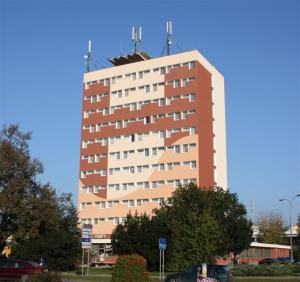 um edifício alto em frente a um parque de estacionamento em Izabella em Puławy