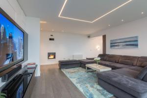 Il comprend un salon doté d'un canapé et d'une télévision à écran plat. dans l'établissement Luxury Apartment Kortina, à Zadar