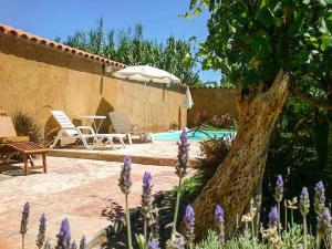 a pool with a table and chairs and an umbrella at Hostal Tierra de Vinos in Cafayate