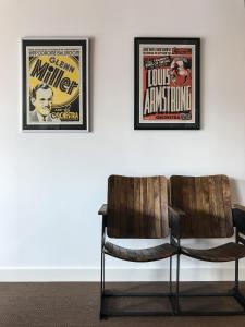 zwei gerahmte Filmplakate an einer Wand mit einem Stuhl in der Unterkunft Jazz Hotel Ascona in Ascona