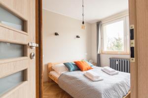 een slaapkamer met een bed met handdoeken erop bij Sea You Apartments- Malczewskiego in Sopot