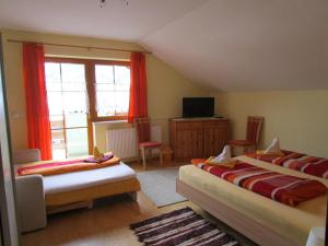 una camera con due letti, una TV e una finestra di Appartment Stiegler a Haus im Ennstal