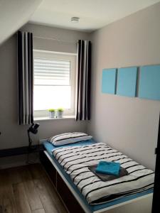 a small bedroom with a bed with a window at Ferienhaus Strandgut in Petersfeld