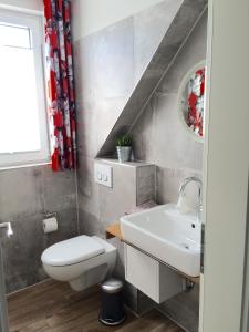 a bathroom with a white toilet and a sink at Ferienhaus Strandgut in Petersfeld +9 photos