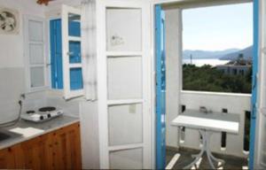 eine Küche mit Blick aus dem Fenster und auf einen Tisch in der Unterkunft PELAGIA KAMPOS MARATHOKAMPOU APARTMENTs in Marathokampos
