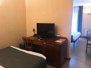 Televiisor ja/või meelelahutuskeskus majutusasutuses Hôtel Vesuvio