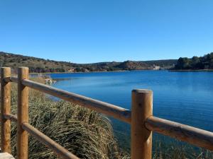 a wooden fence next to a body of water at Escapada Delux in Ossa de Montiel