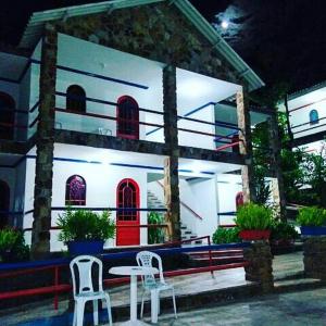 a house with two chairs and a table in front of it at Otellin Triumph Hotel in Triunfo