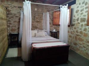 a bedroom with a bed with a canopy and curtains at Casa De Vacances La Vella Era in Arnés