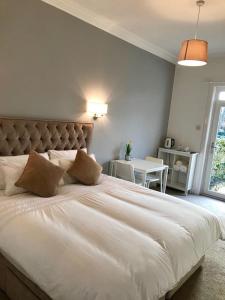 a bedroom with a large white bed and a table at The Doonleigh suite in Ayr