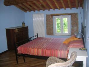 um quarto com uma cama e uma janela em La Coccinella di Silvia e Simone em Massarosa