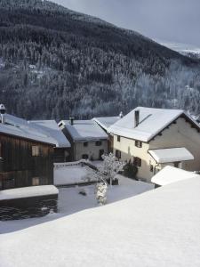 a group of buildings with snow on the roofs at Ferienhaus Tinizong in Tinzen