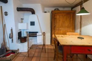 jadalnia z drewnianym stołem i drewnianymi drzwiami w obiekcie Ferienhaus Tinizong w mieście Tinzen