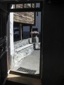 an open door of a building with a vase of flowers at Ferienhaus Tinizong in Tinzen