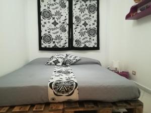 Un dormitorio con una cama con una manta blanca y negra. en amendola24, en Cefalú