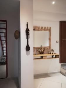 uma cozinha com um espelho e uma espátula na parede em amendola24 em Cefalù