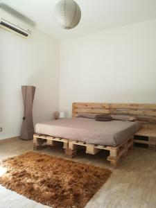 1 dormitorio con 1 cama hecha de paletas de madera en amendola24, en Cefalú