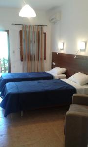 two beds in a room with blue sheets at Megalos Mourtias in Alonnisos
