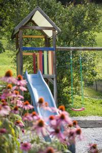 einen Spielplatz mit Rutsche und Schaukel in der Unterkunft Haus Fernblick in Neustift im Stubaital