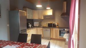 une cuisine avec des appareils en acier inoxydable et des armoires en bois dans l'établissement Le Chalet d'Augusta, à Bourg-Saint-Maurice