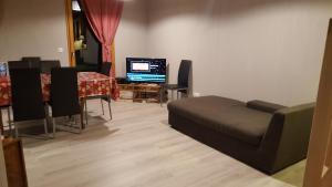 un salon avec un canapé, une table et une télévision dans l'établissement Le Chalet d'Augusta, à Bourg-Saint-Maurice