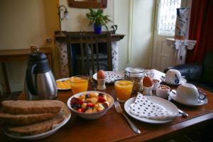 a wooden table with breakfast foods and orange juice at B&B Gasthuis 288 in Delft