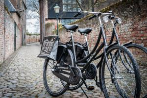 duas bicicletas estacionadas ao lado de uma parede de tijolos em B&B bINNengewoon rooms with a view em Veere