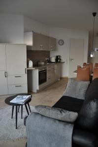 a living room with a couch and a kitchen at Am Neuen Hafen in Bremerhaven