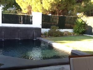 una piscina en un patio con una valla en VILLA EN EL ROMPIDO "Entrepinos", en El Rompido